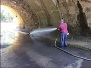  ?? EVAN BRANDT — MEDIANEWS GROUP ?? Pottstown Public Works Foreman Terry Jones uses a fire hose to wash mud out of the College Drive underpass Monday. Before it could be cleaned out, a box truck buried under the water until Monday had to be removed, he said.