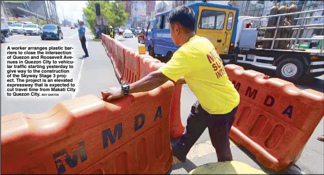  ?? BOY SANTOS ?? A worker arranges plastic barriers to close the intersecti­on of Quezon and Roosevelt Avenues in Quezon City to vehicular traffic starting yesterday to give way to the constructi­on of the Skyway Stage 3 project. The project is an elevated expressway that is expected to cut travel time from Makati City to Quezon City.