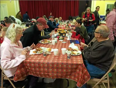  ?? FILE PHOTO ?? A table of diners prepares to dig into their free holiday meal from Kingdom Ministries in 2017.