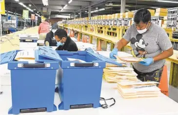  ?? KIM HAIRSTON/BALTIMORE SUN ?? Baltimore City election workers start counting mail-in ballots at the voting machine warehouse.