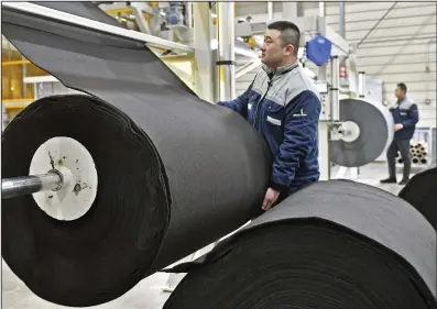  ?? (AP/Chinatopix) ?? Workers produce car mats in a factory of car interior pieces in Yantai, east China’s Shandong province, in February.