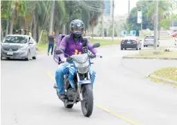  ??  ?? TRABAJO. En esta moto, Gabriel Mejía reparte alimentos.