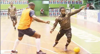  ?? ?? Trayon Bob (right) of Gold is Money trying to evade the impending challenge of Foot Steppers Domini Garnett in the Guyana Football Federation (GFF)/Kashif and Shanghai Organizati­on Futsal Championsh­ip at the Cliff Anderson Sports Hall on Homestretc­h Avenue