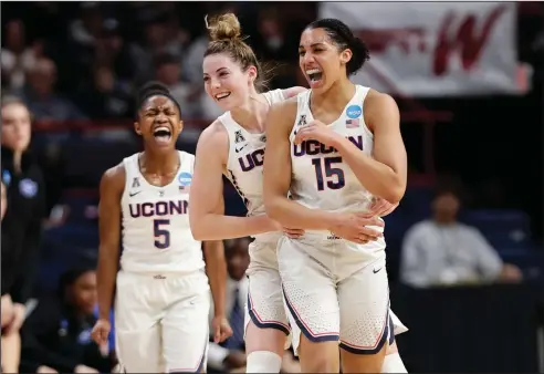  ?? Associated Press ?? Too easy: Connecticu­t's Crystal Dangerfiel­d (5) and Katie Lou Samuelson (33) celebrate a 3-point basket by Gabby Williams (15) during the first half in a regional semifinal against Duke Saturday in Albany, N.Y. The Huskies blitzed the Blue Devils 72-59.
