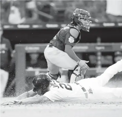  ?? PAUL SANCYA/AP ?? The Tigers’ JaCoby Jones scores the winning run as Cubs catcher Tony Wolters waits for the throw in the 10th inning Saturday.