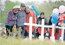  ?? [AP PHOTO] ?? Family and friends gather around a makeshift memorial for the victims of the First Baptist Church shooting Friday at Sutherland Springs Baptist Church in Sutherland Springs, Texas.