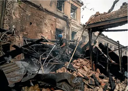  ?? AP ?? A firefighte­r works to extinguish a blaze after a Russian attack damaged a building at a technical school in Slovyansk, Ukraine yesterday.