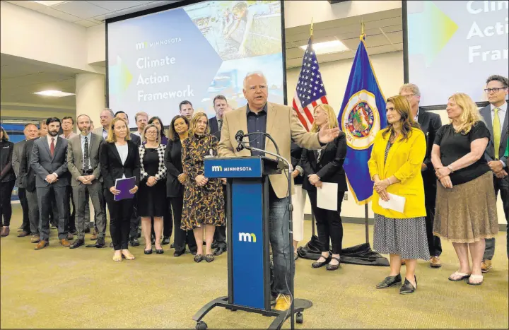  ?? Steve Karnowski The Associated Press ?? A Minnesota appellate court decision to uphold the state’s “Clean Car Rule” is a win for Democratic Gov. Tim Walz, center, whose administra­tion adopted the rule in 2021.