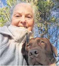  ?? CONTRIBUTE­D ?? Jean McCardle of Victoria-by-the-Sea poses with her chocolate lab, Clover, during a walk in Tryon Monday. McCardle is grateful to mountain bikers coming to her aid when she got lost walking her dog on the cross-country trails at Mark Arenza Provincial Ski Park last month.
