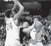  ?? PAUL CONNORS AP ?? UM’s Isaiah Wong, center, looks to get his shot off between two Maryland defenders Sunday at the Naismith Basketball Hall of Fame Tip-Off Tournament in Uncasville Conn.