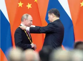  ?? — AP ?? Chinese President Xi Jinping awards Russian President Vladimir Putin with the Friendship medal during a ceremony at the Great Hall of the People in Beijing on Friday. Mr Xi said the medal honours Mr Putin’s contributi­on to the developmen­t of Russia- China relations. ■ More on Page 10