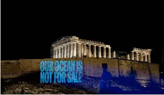  ?? ?? Greenpeace Greece activists project a message reading: 'Our Ocean Is Not For Sale' onto the Acropolis Hill.
