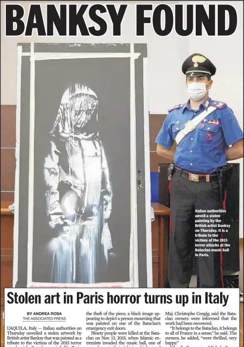  ??  ?? Italian authoritie­s unveil a stolen painting by the British artist Banksy on Thursday. It is a tribute to the victims of the 2015 terror attacks at the Bataclan music hall in Paris.
