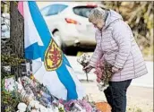  ?? ANDREW VAUGHAN/THE CANADIAN PRESS ?? A woman pays respects Thursday in Portapique, Nova Scotia, for victims of Canada’s worst mass shooting.