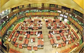  ??  ?? KUWAIT: Traders pictured inside the Kuwait Stock Exchange in this file photo.