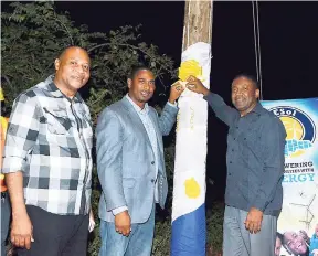  ??  ?? In this file photo, then Energy Minister Phillip Paulwell (right) is joined by PNP candidate Hugh Buchanan (centre) and chairman of NESol, Garfield Daley, to officially commission into service electricit­y supply for 29 houses in Gillard in southwest St Elizabeth.