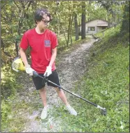  ?? NWA Democrat-Gazette/FLIP PUTTHOFF ?? Austin Mondello, a member of the Young Men’s Service League, works Saturday at Restoratio­n Village in Little Flock.