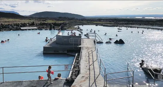  ?? PHOTOS: TIM JOHNSON ?? Bathers soak in the sun and the blue mineral-rich waters at Mývatn Nature Baths.