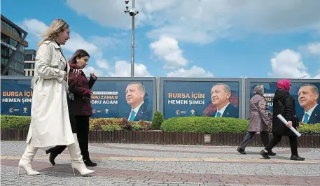  ?? | PHOTO : DAVID ADEMAS, OUEST-FRANCE ?? Des femmes de Bursa, dans le nord-ouest de la Turquie, passent devant des affiches électorale­s du président Erdogan.