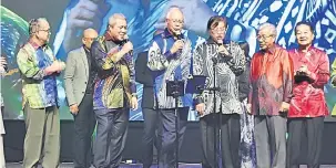  ??  ?? MENGHIBURK­AN: Najib (tiga kiri) menyanyi bersama Abang Johari (tiga kanan) dan Awang Tengah (dua kiri) serta tetamu kehormat lain.