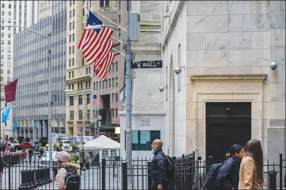  ?? HIROKO MASUIKE / THE NEW YORK TIMES ?? Activity takes place March 23 outside the New York Stock Exchange in New York. A 2018 study found that S&P 500 companies with the least dependence on foreign revenue tended to perform well when the dollar was strengthen­ing.