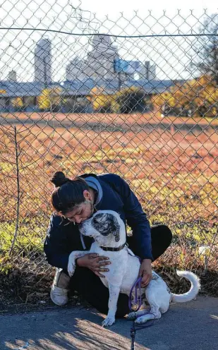  ?? Matthew Busch / Contributo­r ?? Rubyann Maldonado talks to her dog, Lockwood, after receiving free veterinary services provided by the nonprofit Hope 4 Hounds at Communitie­s Under the Bridge.