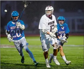  ?? SARAH GORDON/THE DAY ?? East Lyme’s James McCoy (17) passes the ball on the move in front of Waterford’s Kyle Cardoza (11) and Spencer Hoagland (20) during Thursday night’s ECC boys’ lacrosse tournament championsh­p game. The Vikings rallied for an 11-9 victory over the Lancers.