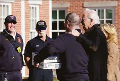  ?? Susan Walsh / Associated Press ?? President Joe Biden, with his arm on the shoulder of Nantucket Fire Department Chief Michael Cranson, and first lady Jill Biden, right, visit with firefighte­rs on Thanksgivi­ng Day at the Nantucket Fire Department in Nantucket, Mass.