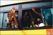  ?? THE ASSOCIATED PRESS ?? Arrested protesters wave to people while onboard a bus that is getting out of Insein prison and will transport them to an undisclose­d location Wednesday in Yangon, Myanmar.