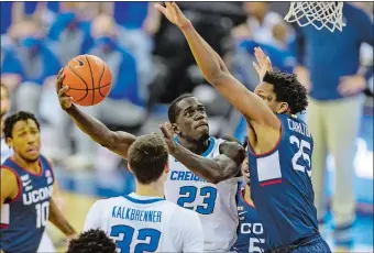  ?? JOHN PETERSON/AP PHOTO ?? Creighton forward Damien Jefferson (23) shoots over UConn center Josh Carlton (25) during Saturday’s Big East game in Omaha, Neb. The No. 11 Bluejays beat the No. 23 Huskies 74-66.