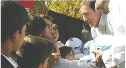  ?? MIKE ARMSTRONG / GLOBAL NATIONAL / POOL / FILES ?? Peter Mackay, second from right, talks to Afghan children in Kandahar City when he was Canada’s defence minister
in 2007 and he distribute­d the first of 500 soccer balls donated to Afghan children by a 12-year-old Ontario boy.