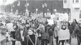  ?? JESSICA ANDERSON/BALTIMORE SUN ?? A crowd gathers outside the library in Highlandto­wn, ready to march around Patterson Park to show support for immigrants.