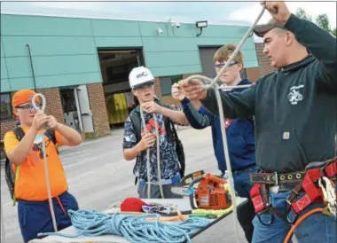  ?? JOHN BREWER — ONEIDA DAILY DISPATCH ?? Students practice tying proper safety rope knots during Constructi­on Careers Day at the Madison-Oneida BOCES campus.