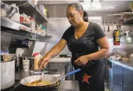  ??  ?? Soul Bowl’z owner Nima Romney cooks inside her food truck at the Bayview Bistro park.