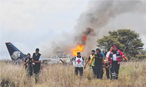  ?? Picture: AP ?? SAVED: Red Cross and other rescue workers help injured people from an Aeromexico airliner which crashed near Durango, Mexico, on Tuesday.