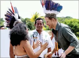  ??  ?? FEATHER IN HIS CAP: Harry was ‘crowned’ with a feather headdress in Guyana yesterday. The British prince began dating Ms Markle this year