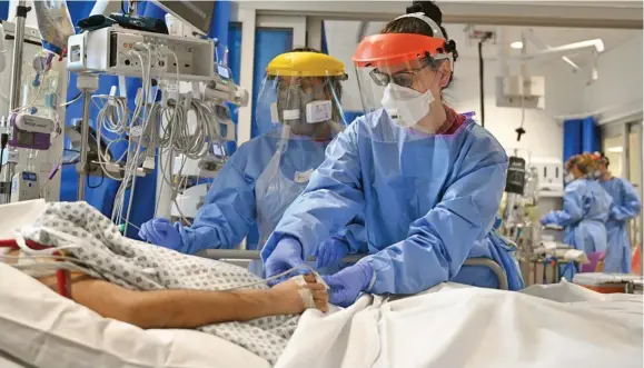  ?? Photo: PA ?? Medical staff at a London hospital treat a patient in the COVID-19 ward.