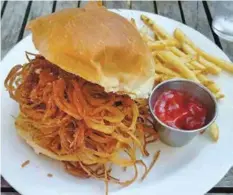  ??  ?? The half-pound house-blend 1885 Burger piles pimento cheese, chow-chow, house-cured beef bacon, fried tobacco onions, Creole mayo and lettuce on a Niedlov’s bun.