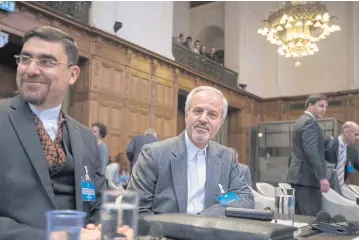  ?? PHOTOS BY AP ?? Mohammed Zahedin Labbaf, centre, agent for the Islamic Republic of Iran, waits for judges to enter the World Court.