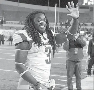  ?? NWA Democrat-Gazette/MICHAEL WOODS ?? Arkansas junior running back Alex Collins waves to fans after rushing for 185 yards and three touchdowns in Saturday’s Liberty Bowl in Memphis. Collins has yet to announce whether he will return to Arkansas for his senior season. More photos are...