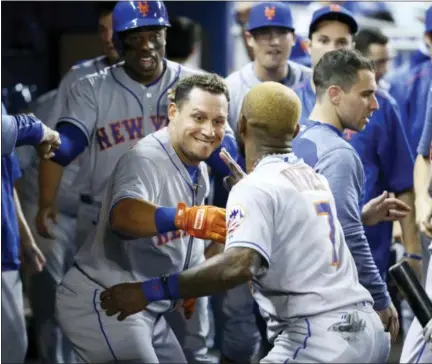  ?? WILFREDO LEE — THE ASSOCIATED PRESS ?? The Mets’ Asdrubal Cabrera, center, and Jose Reyes (7) celebrate after Cabrera hit a home run in the first inning against the Marlins on Wednesday. The Mets won 8-0.