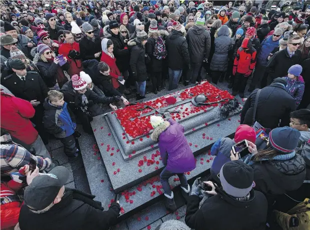  ?? JUSTIN TANG / THE CANADIAN PRESS ?? People lay poppies on the Tomb of the Unknown Soldier at the National War Memorial after Remembranc­e Day ceremonies in Ottawa on Sunday.