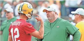  ??  ?? Packers quarterbac­k Aaron Rodgers talks with coach Mike McCarthy during training camp.
