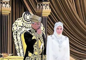  ?? ?? Sultan abdullah kissing the Keris Panjang diraja as Tunku azizah looks on during the installati­on ceremony at Istana negara. — Bernama