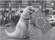  ?? TOLGA AKMEN / AFP / GETTY IMAGES ?? A demonstrat­or waves a European Union (EU) flag in a protest outside in central London on Monday.