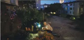  ?? ?? Yaizid and Samia Bendaif work on their garden at night Oct. 26 outside their home.