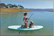  ?? JOSE CARLOS FAJARDO — STAFF PHOTOGRAPH­ER ?? Nicole Strupeni of South San Francisco paddleboar­ds with her dog Jaxson while at the Oak Shores Day Use Area at Lake Berryessa in Napa in 2021.