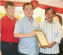  ??  ?? 砂拉越漁船公會主席夏­忠鈿（右）移交感謝狀予許慶璋。左為顧問林生昌。