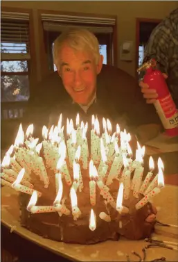  ?? Courtesy photo / Chris Bateman ?? With an extinguish­er at the ready, the writer gets ready to blow out the candles on his 75th birthday “porcupine cake.”