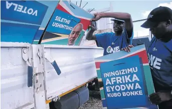  ?? /ZIPHOZONKE LUSHABA ?? Tshepo Mogaodi and Kuly Fotoyi attend to DA election posters during the party’s election campaign in Tembisa yesterday.